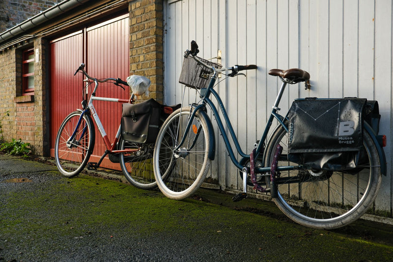 Two bicycles against a garage in Brugge, Belgium, showcasing urban lifestyle.